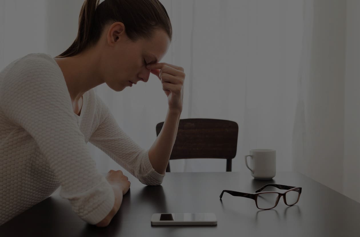 A woman sitting at a table with her head down.