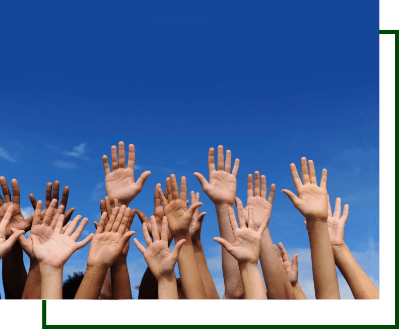 A group of people raising their hands in the air.