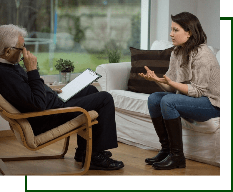 A woman talking to an older man in a chair.