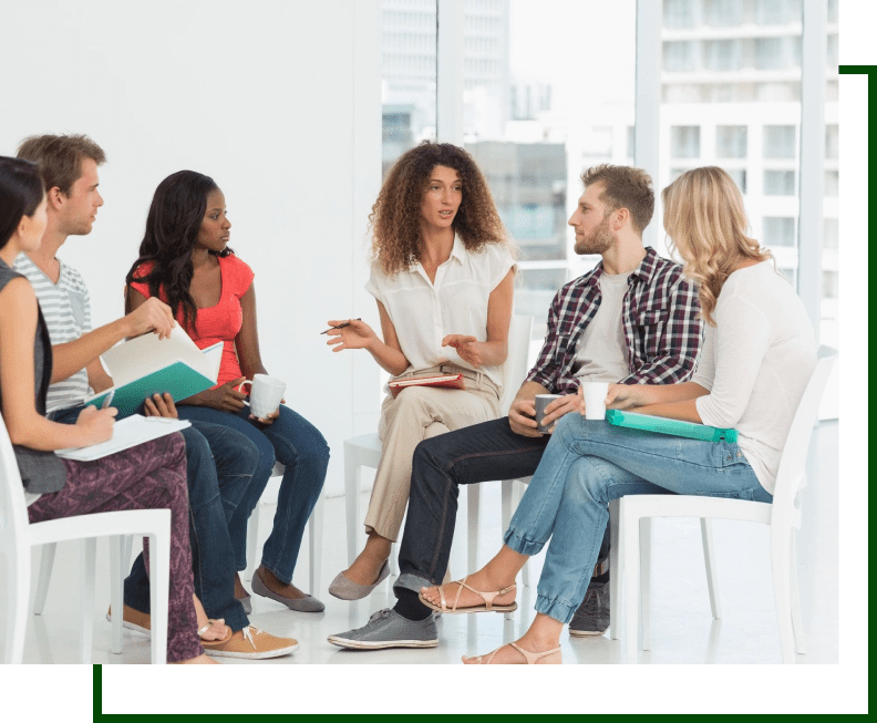 A group of people sitting in chairs talking.