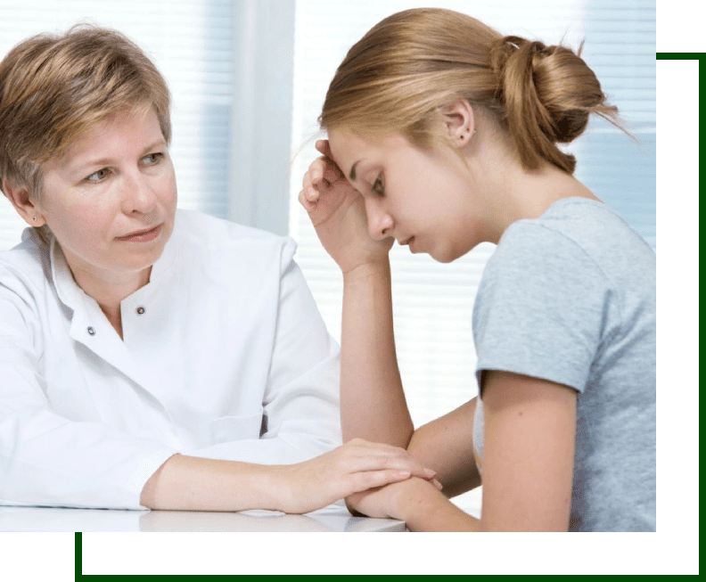 A woman sitting next to a doctor with her hand on the forehead of another girl.