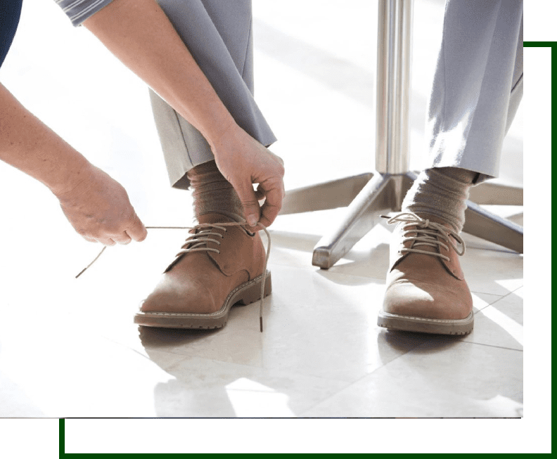 A person tying their shoe laces on the ground.