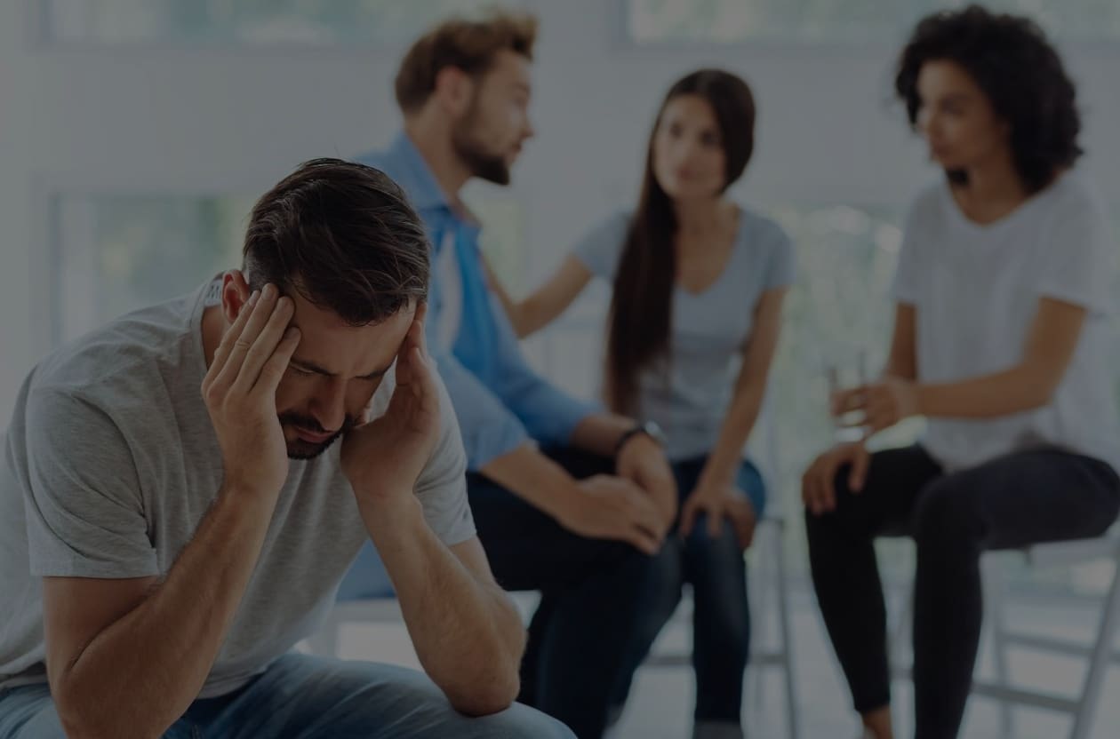 A group of people sitting around each other.