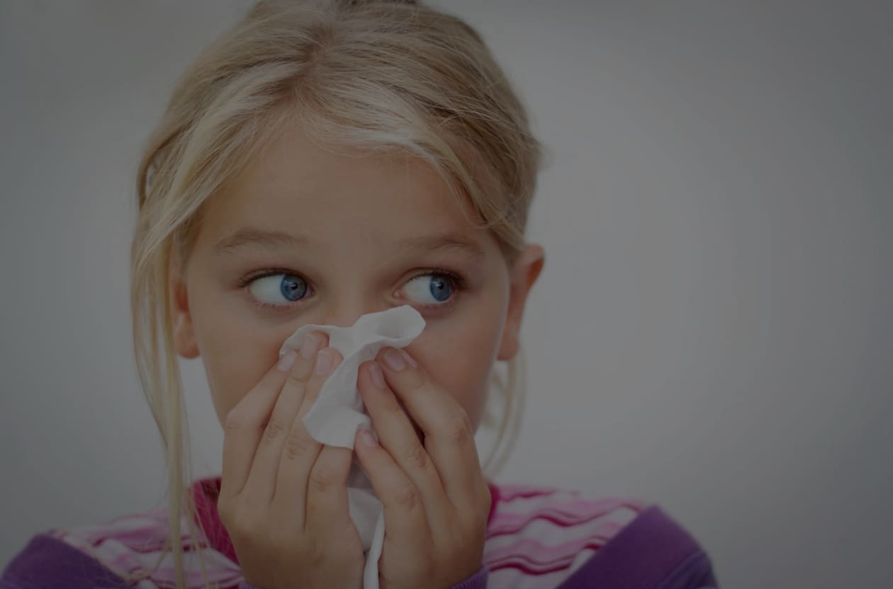 A little girl with a tissue in her hand.